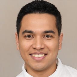 Joyful latino young-adult male with short  black hair and brown eyes