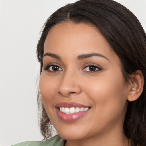 Joyful latino young-adult female with long  brown hair and brown eyes