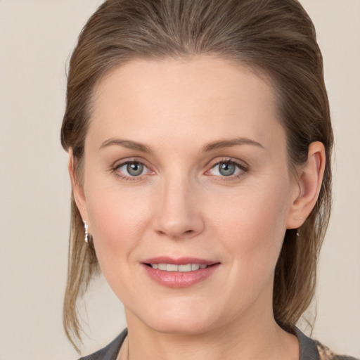 Joyful white young-adult female with medium  brown hair and grey eyes