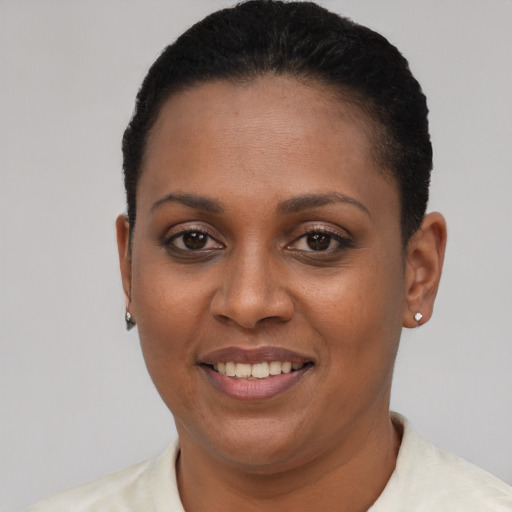 Joyful black young-adult female with short  black hair and brown eyes
