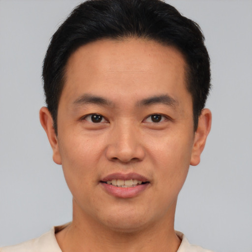 Joyful asian young-adult male with short  brown hair and brown eyes