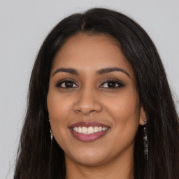 Joyful latino young-adult female with long  brown hair and brown eyes