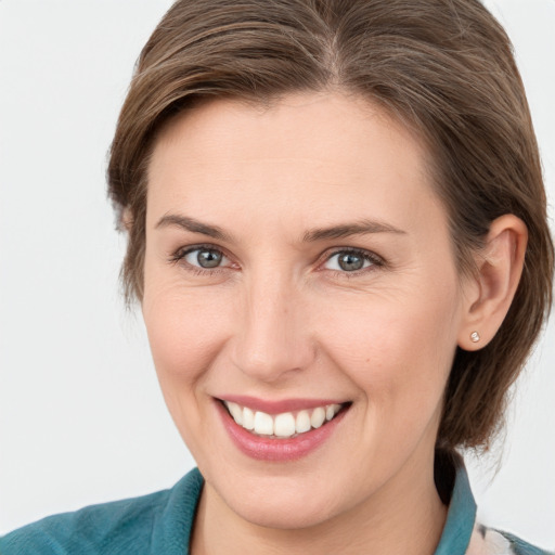 Joyful white young-adult female with medium  brown hair and grey eyes