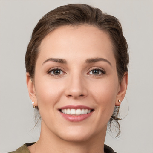 Joyful white young-adult female with medium  brown hair and grey eyes