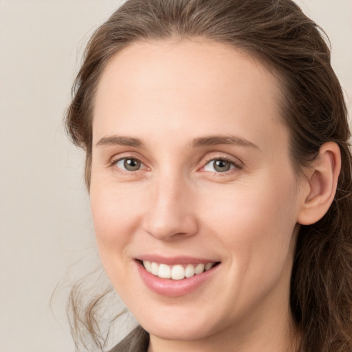 Joyful white young-adult female with long  brown hair and grey eyes