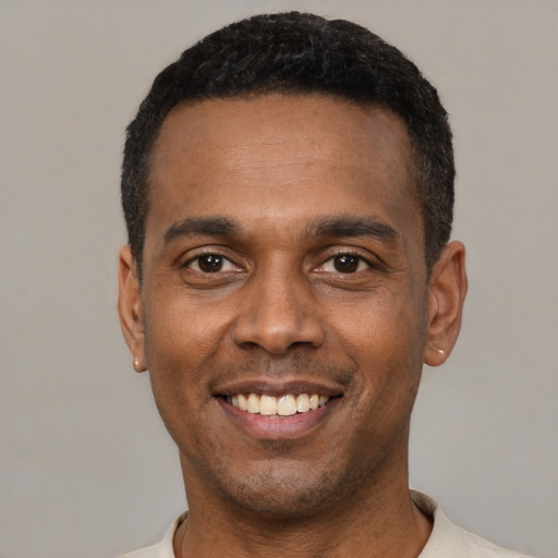 Joyful latino young-adult male with short  black hair and brown eyes