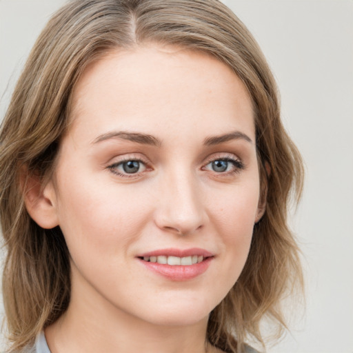 Joyful white young-adult female with medium  brown hair and blue eyes