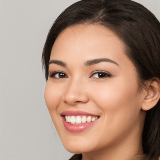 Joyful white young-adult female with long  brown hair and brown eyes