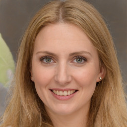 Joyful white adult female with long  brown hair and green eyes