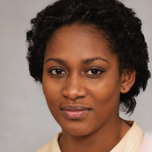 Joyful black young-adult female with short  black hair and brown eyes