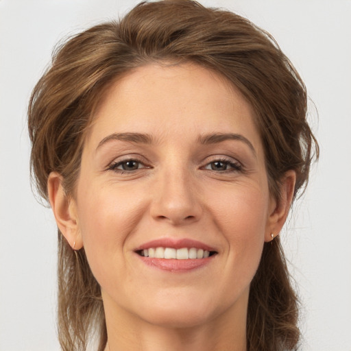 Joyful white adult female with medium  brown hair and grey eyes