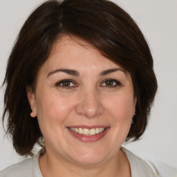 Joyful white adult female with medium  brown hair and brown eyes