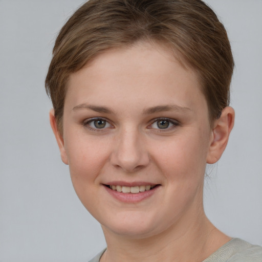 Joyful white young-adult female with short  brown hair and grey eyes