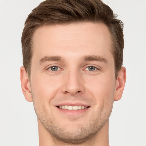 Joyful white young-adult male with short  brown hair and grey eyes