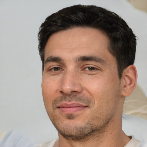 Joyful white adult male with short  black hair and brown eyes