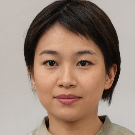 Joyful asian young-adult female with medium  brown hair and brown eyes