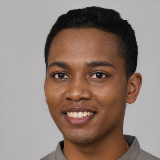 Joyful black young-adult male with short  black hair and brown eyes