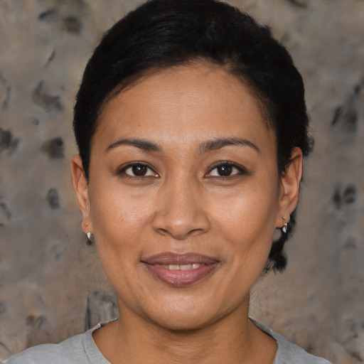 Joyful black adult female with short  black hair and brown eyes