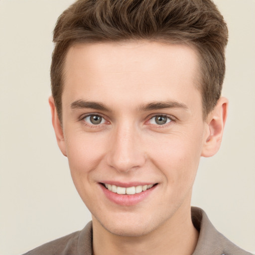 Joyful white young-adult male with short  brown hair and grey eyes