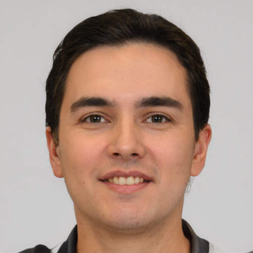 Joyful white young-adult male with short  black hair and brown eyes