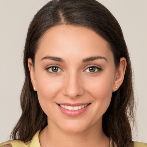 Joyful white young-adult female with long  brown hair and brown eyes