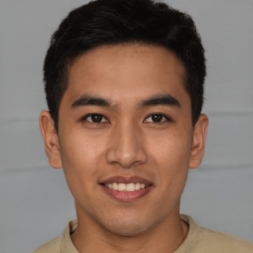 Joyful latino young-adult male with short  brown hair and brown eyes
