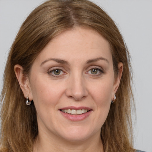 Joyful white adult female with long  brown hair and grey eyes