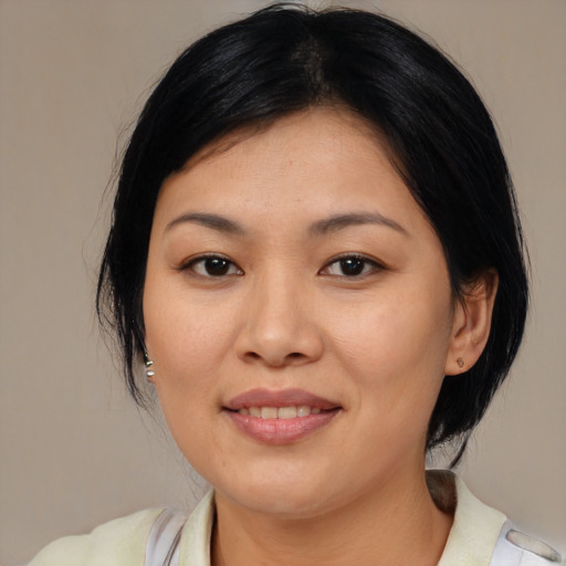 Joyful asian adult female with medium  black hair and brown eyes
