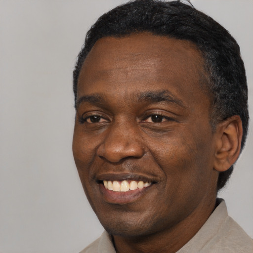 Joyful black young-adult male with short  black hair and brown eyes