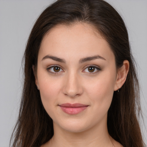 Joyful white young-adult female with long  brown hair and brown eyes