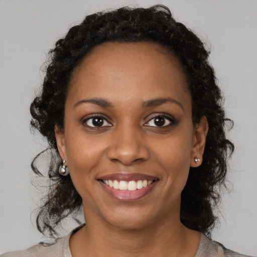Joyful black young-adult female with medium  brown hair and brown eyes