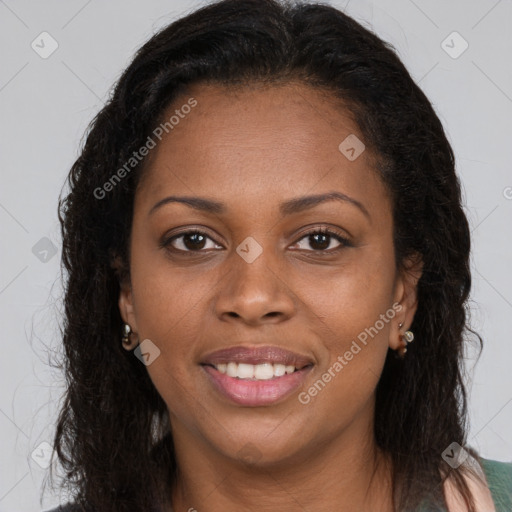 Joyful black young-adult female with long  brown hair and brown eyes