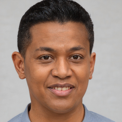 Joyful latino adult male with short  brown hair and brown eyes