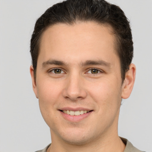 Joyful white young-adult male with short  brown hair and grey eyes