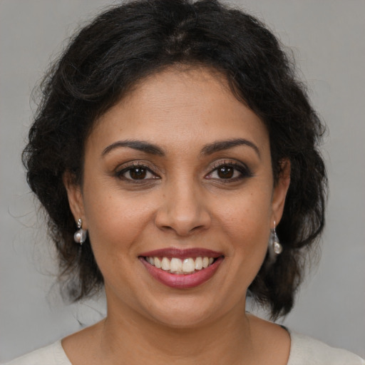 Joyful latino young-adult female with medium  brown hair and brown eyes