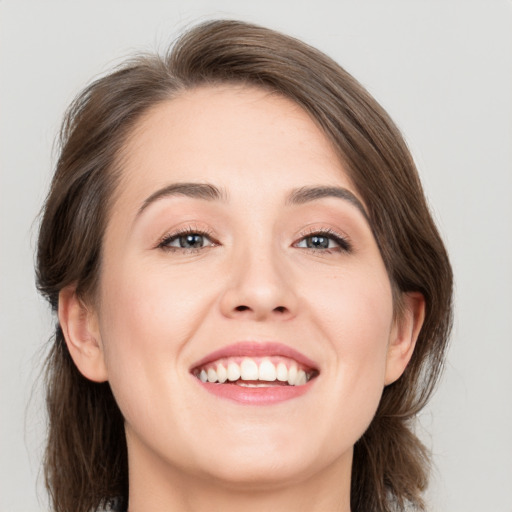 Joyful white young-adult female with medium  brown hair and grey eyes