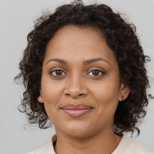 Joyful black adult female with medium  brown hair and brown eyes