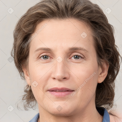 Joyful white adult female with medium  brown hair and grey eyes