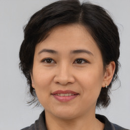 Joyful asian adult female with medium  brown hair and brown eyes