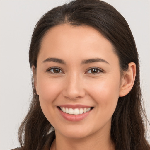 Joyful white young-adult female with long  brown hair and brown eyes