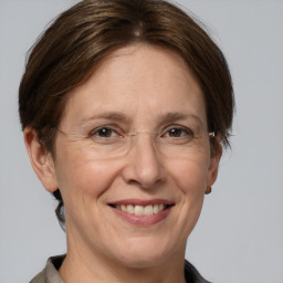 Joyful white adult female with medium  brown hair and grey eyes