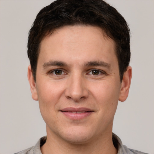 Joyful white young-adult male with short  brown hair and brown eyes