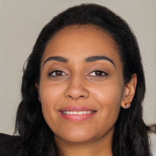 Joyful latino young-adult female with long  black hair and brown eyes