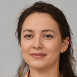 Joyful white adult female with long  brown hair and brown eyes