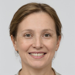 Joyful white adult female with medium  brown hair and grey eyes