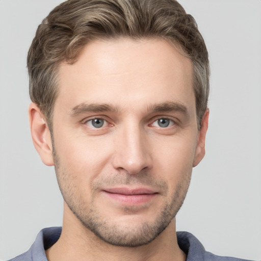 Joyful white young-adult male with short  brown hair and grey eyes