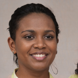 Joyful black young-adult female with medium  brown hair and brown eyes