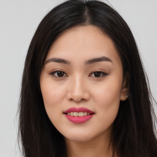 Joyful asian young-adult female with long  brown hair and brown eyes
