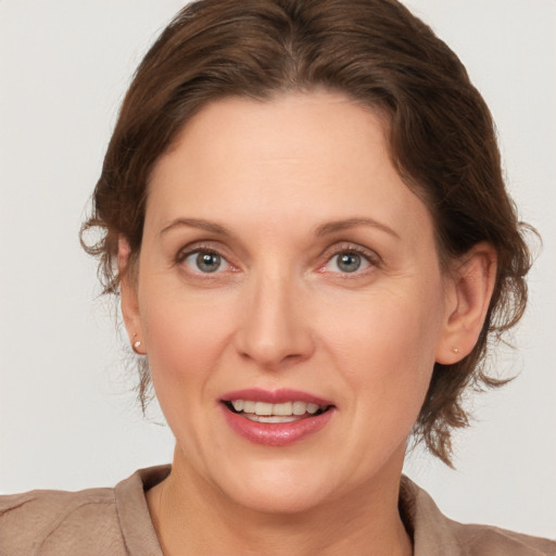 Joyful white adult female with medium  brown hair and grey eyes