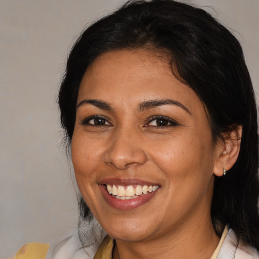 Joyful latino adult female with medium  brown hair and brown eyes
